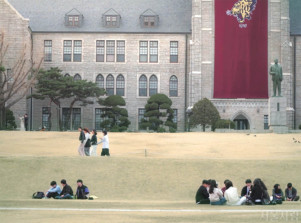 잔디밭에 삼삼오오 둘러앉아 이야기를 나누는 학생들. 고려대학교 본관 앞.