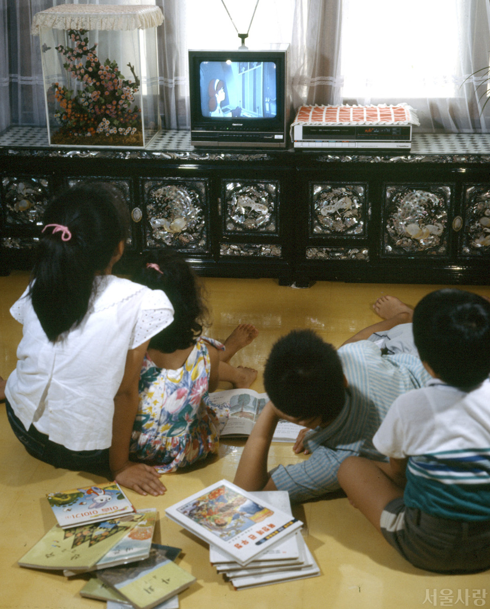 책은 뒷전, 애니메이션 비디오에 빠져 있는 아이들(1987년). &copy;연합뉴스